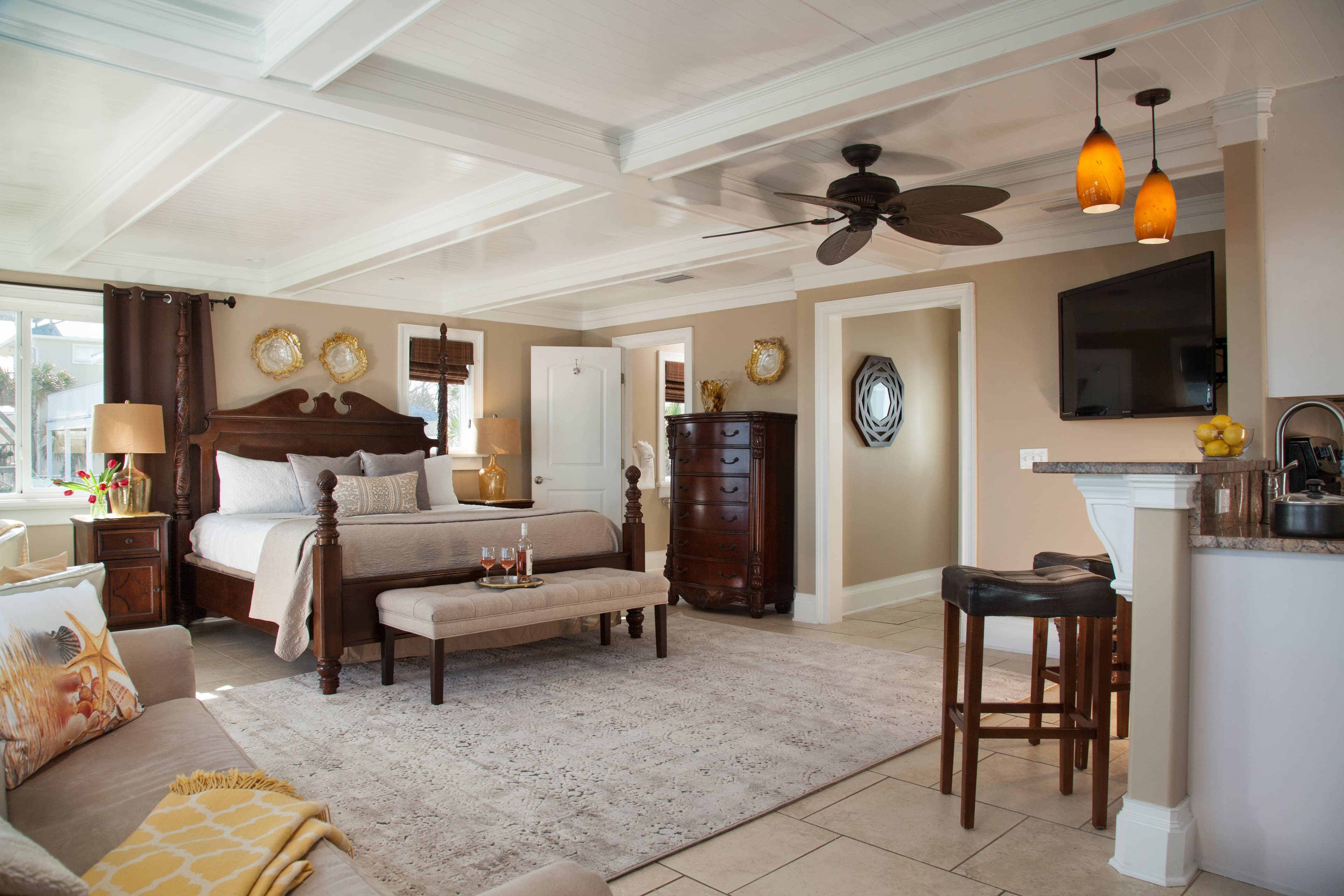 king bed and bench and stools and kitchen bar