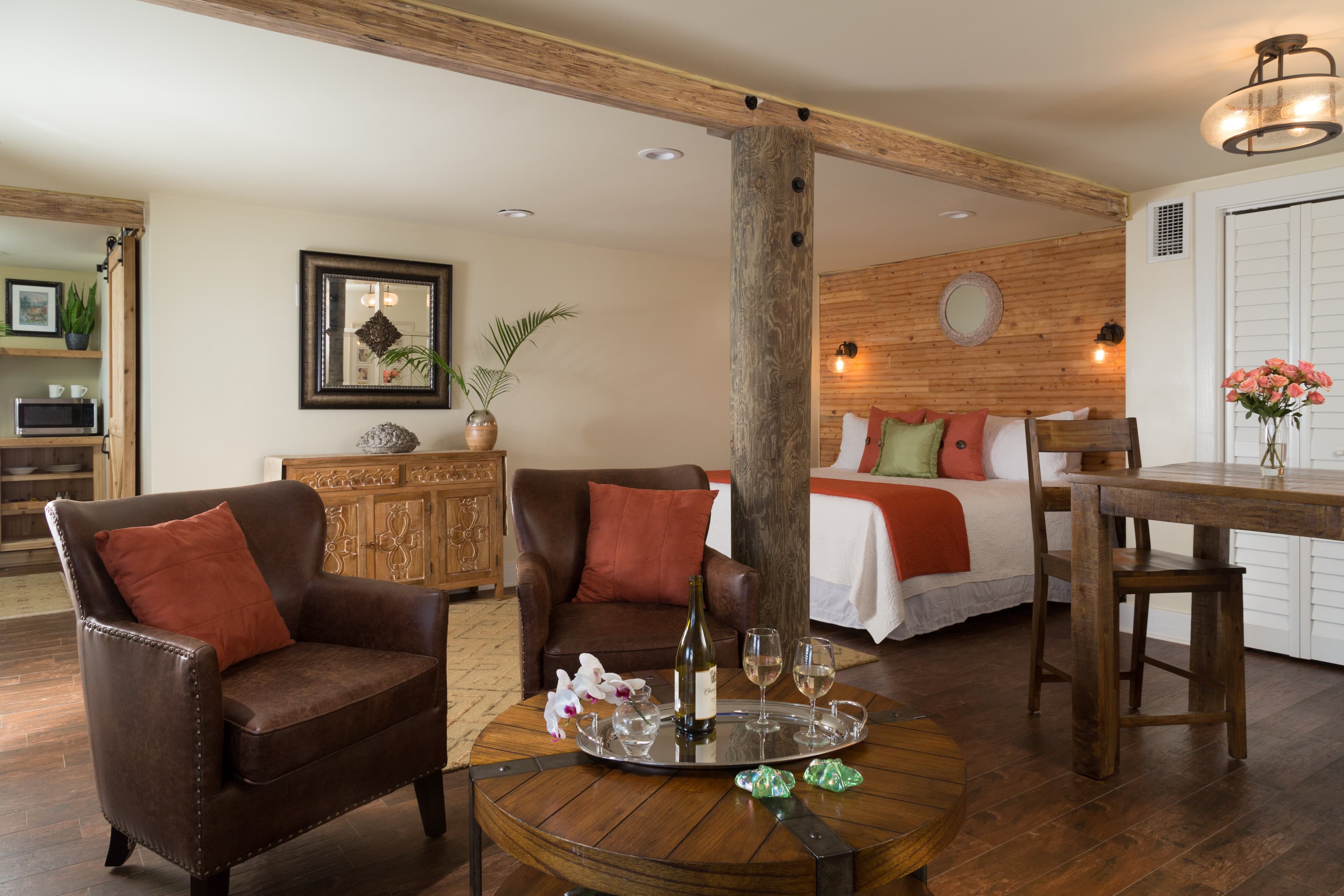 white walls 2 leather chairs king bed wooden wall