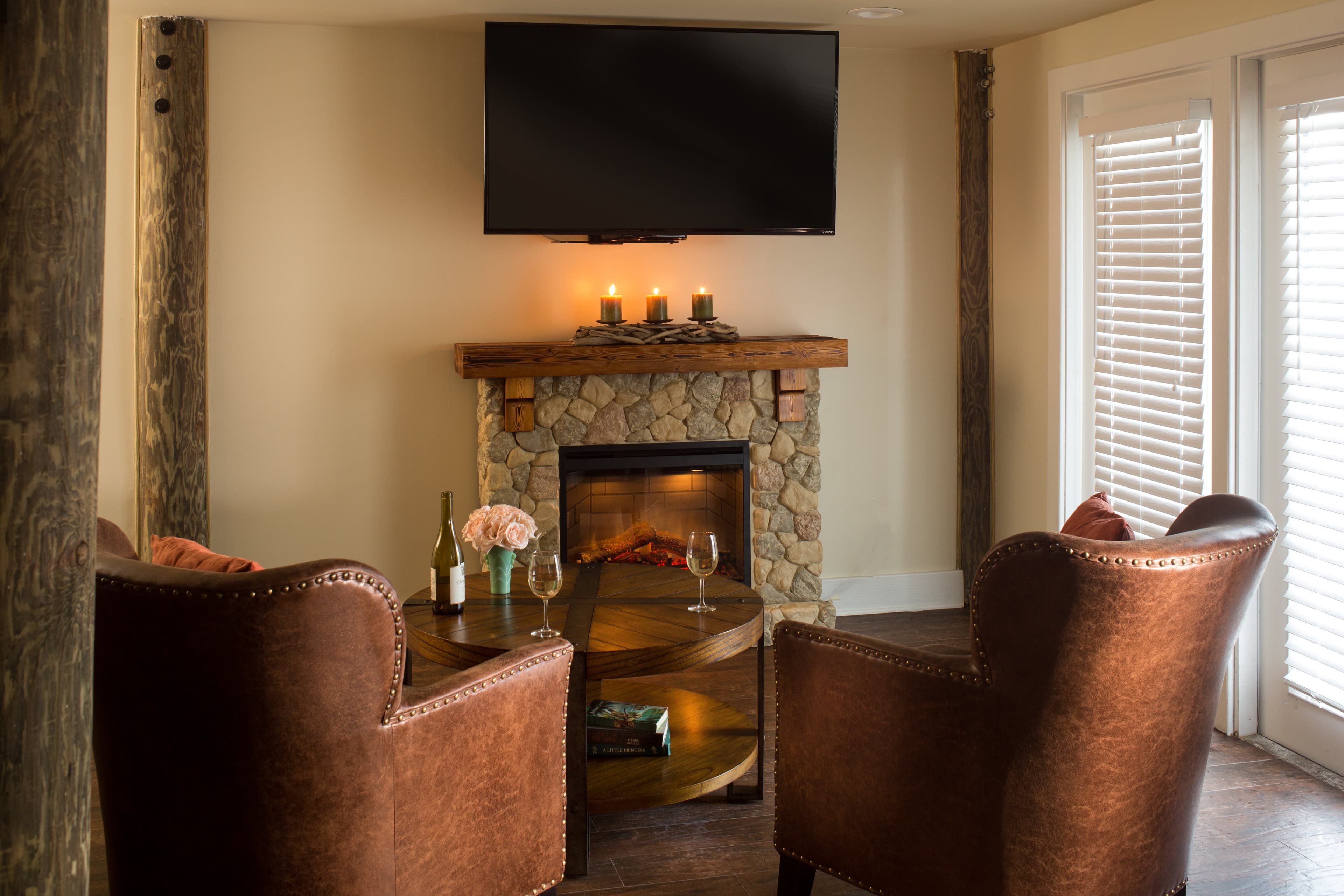 fireplace with television and leather chairs