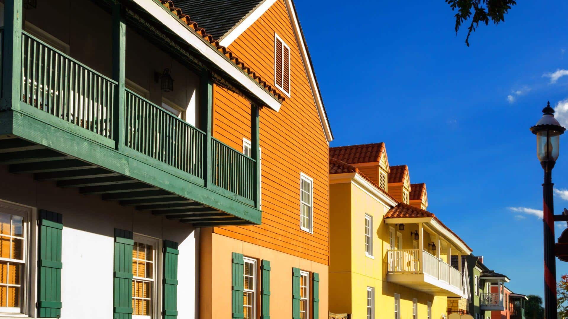 A row of colorful houses with balconies under a clear blue sky. A row of colorful houses with balconies under a clear blue sky.
