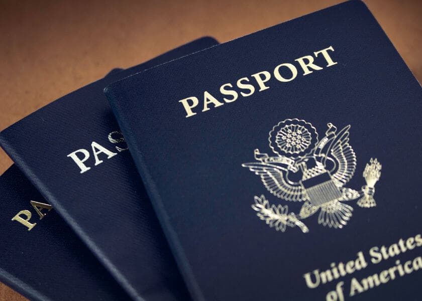 Three United States passports stacked on a surface. Three United States passports stacked on a surface.