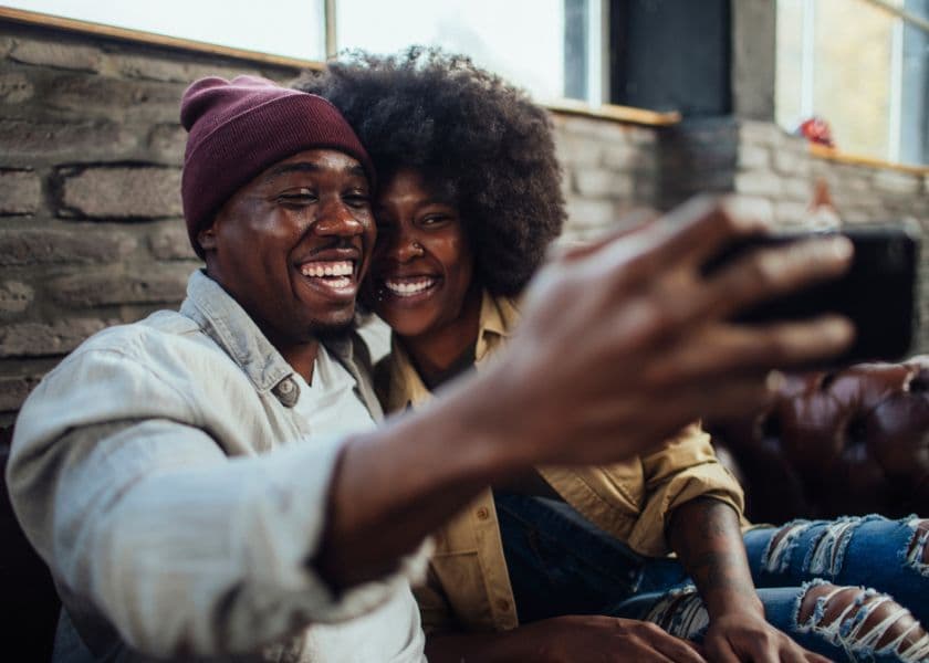 A smiling couple takes a selfie together in a cozy indoor setting. A smiling couple takes a selfie together in a cozy indoor setting.