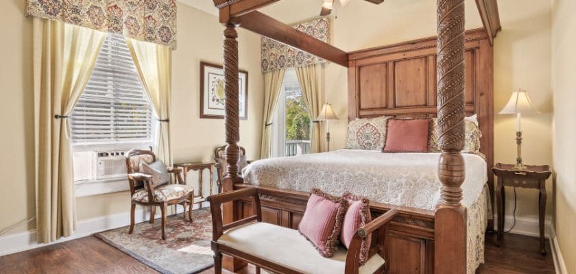 A cozy bedroom featuring a four-poster bed, soft lighting, and elegant decor.