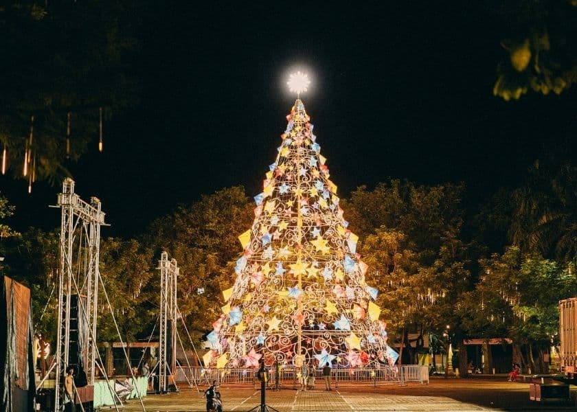 A large illuminated outdoor Christmas tree glowing at night in a public plaza. A large illuminated outdoor Christmas tree glowing at night in a public plaza.