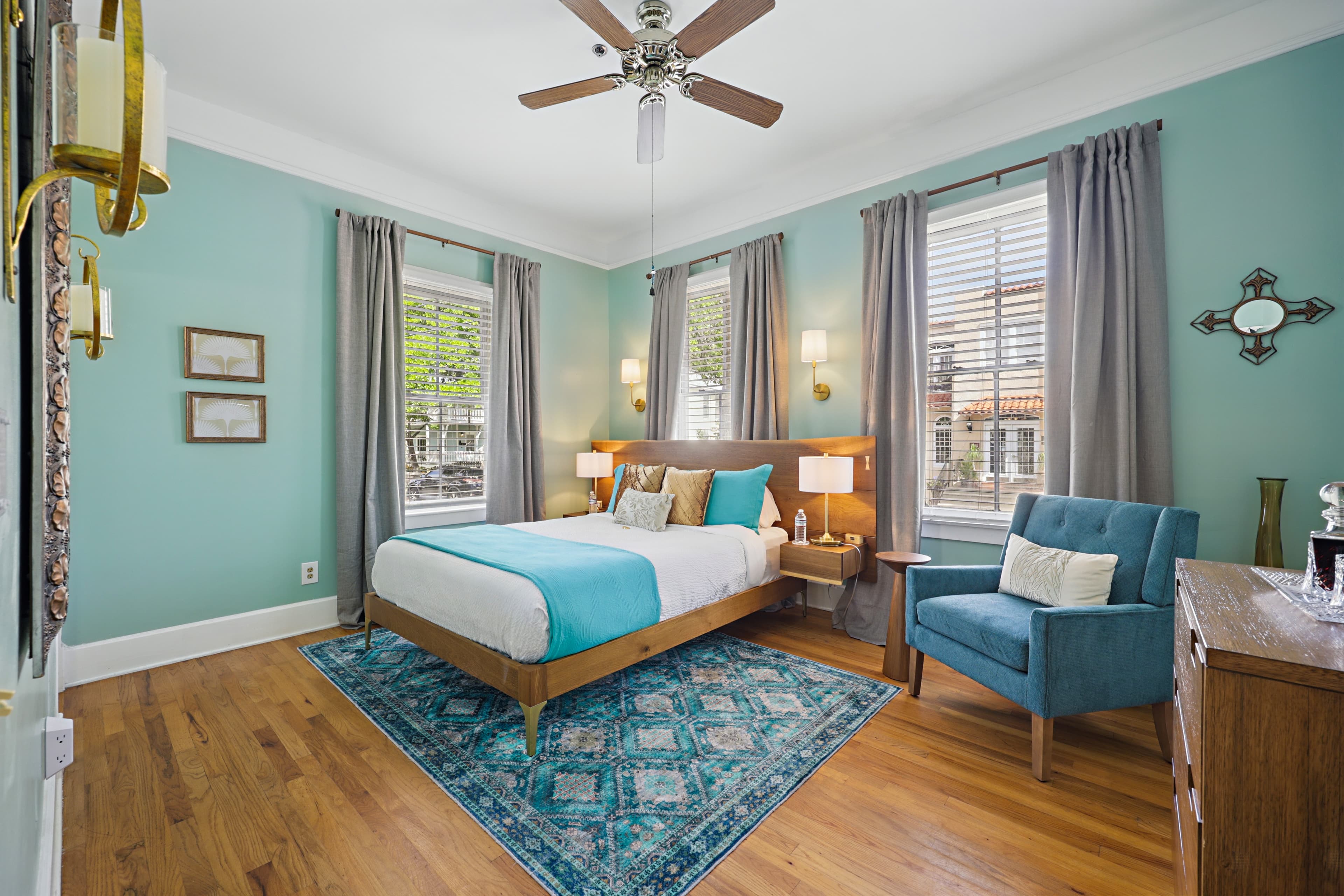 Beautiful turquoise guest room with 3 large windows, hard wood floors, ceiling fan.