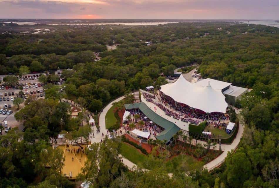Aerial view of a large concert venue surrounded by green trees