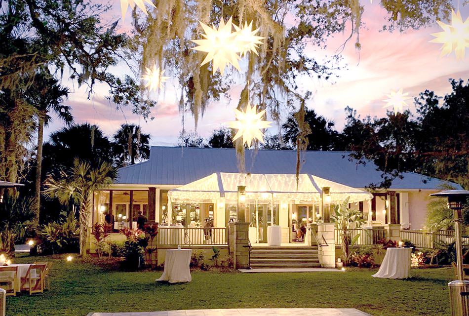 Building set up for an evening event with lights in a gazebo covering cocktail tables