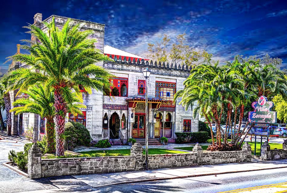 Artist drawing of large white building with decorative doors and windows surrounded by palm trees