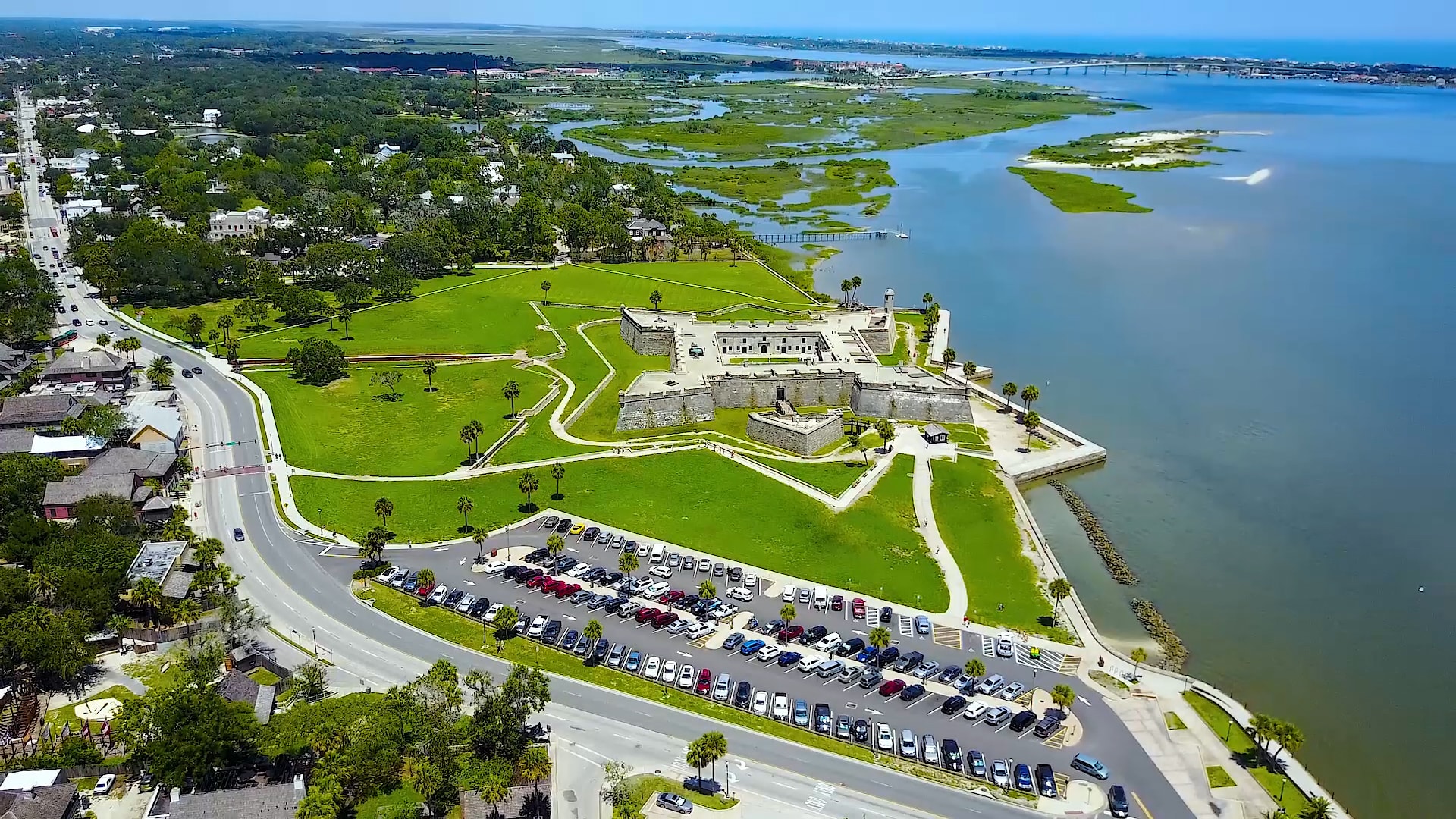 Aerial view of old fort surrounded by green grass and large body of water