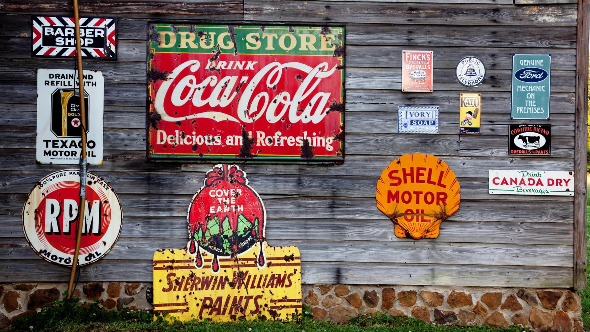 Side of old wooden bar filled with multiple antique metal signs
