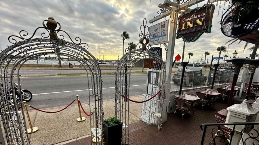 Exterior view of property's entrance with an outside dining space for a Martini Bar that has views of the water