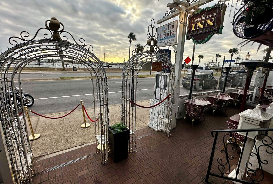 Exterior view of property's entrance with an outside dining space for a Martini Bar that has views of the water