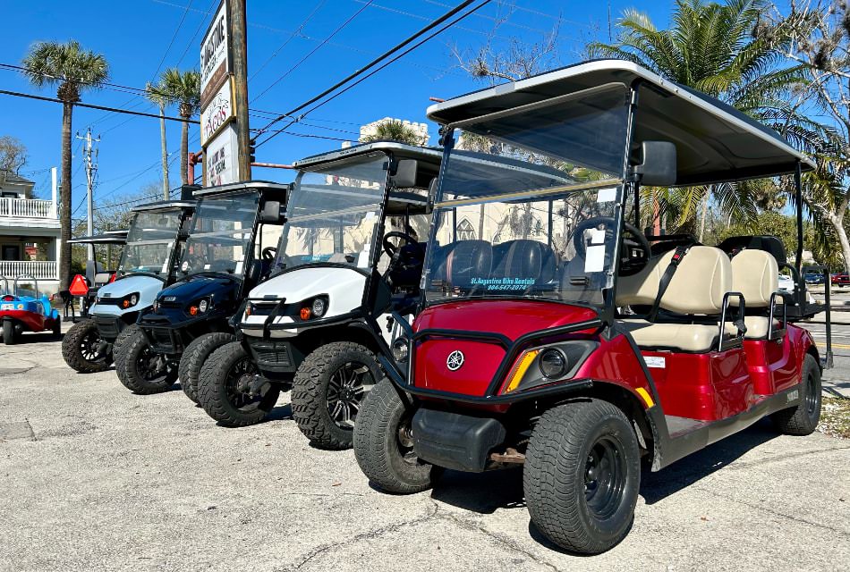 Multiple-colored golf carts lined up in a parking lot